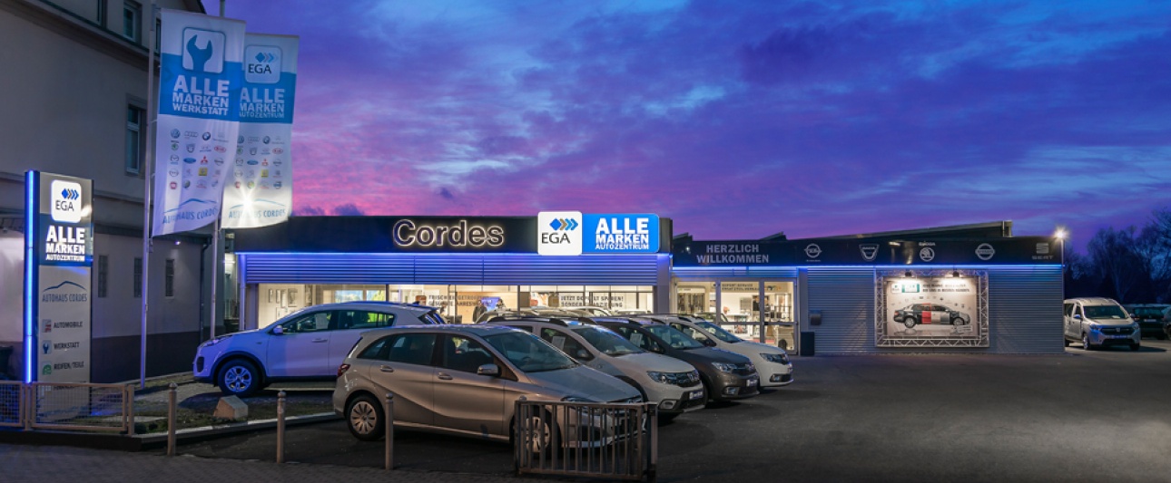 Außenansicht der CI am Autohaus Cordes mit Beleuchtung bei Dunkelheit