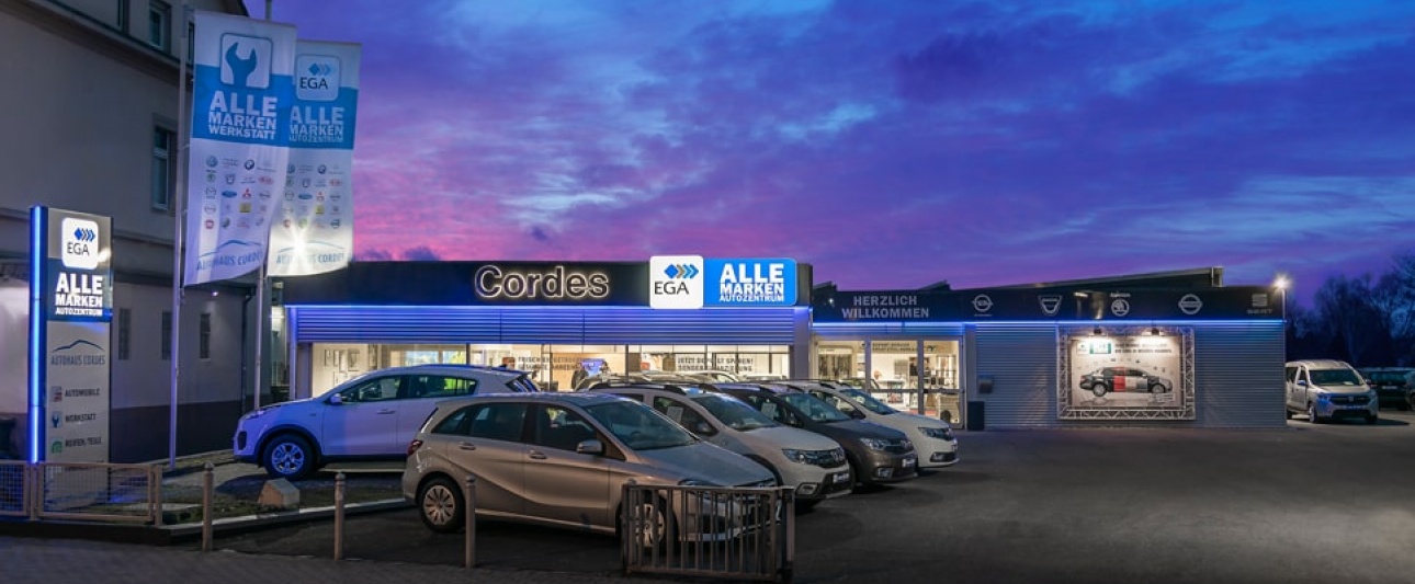 Außenansicht der CI am Autohaus Cordes mit Beleuchtung bei Dunkelheit